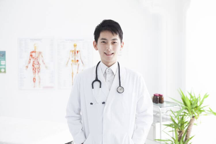 微笑んでいる男性の医者