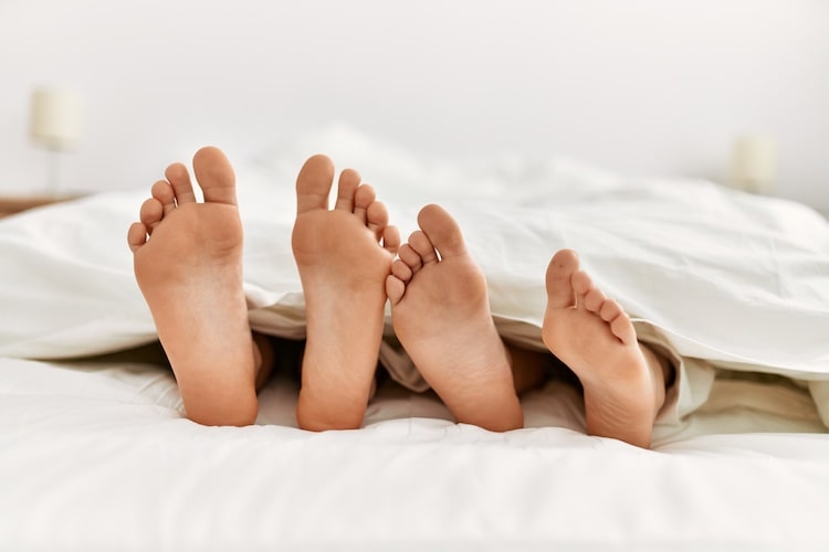 ベッドの中のカップルの足