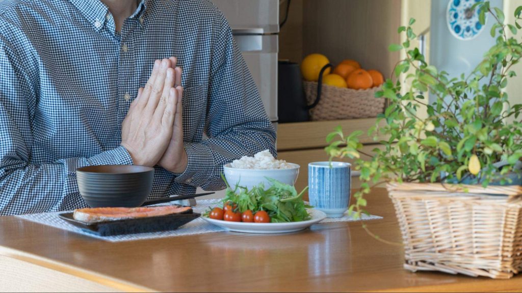 食事の前に手を合わせている人