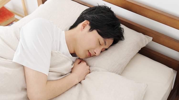 ベッドで眠る男性